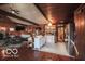Large, wood-paneled living room features a fireplace and kitchen area, perfect for gatherings at 9464 N State Rd 135, Morgantown, IN 46160