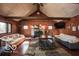 Inviting living room with a fireplace, wood paneled walls, and multiple windows providing ample natural light at 9464 N State Rd 135, Morgantown, IN 46160