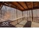 Spacious screened-in porch with wood flooring, railing, and views of surrounding woods at 9464 N State Rd 135, Morgantown, IN 46160