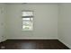 A spacious bedroom with dark wood flooring and a window for natural light at 9685 Glowing Flame Dr, Fishers, IN 46037