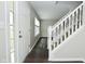 Bright entryway featuring a white front door with glass panels and a staircase with white railing, complemented by hardwood floors at 9685 Glowing Flame Dr, Fishers, IN 46037