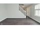 Open living space featuring hardwood floors and neutral paint, with a staircase and window providing natural light at 9685 Glowing Flame Dr, Fishers, IN 46037