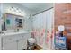 Cozy bathroom featuring a floral shower curtain and a pop of color from exposed brick creating a unique space at 115 N Spring St, Greenfield, IN 46140