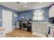 Convenient laundry room with modern washer and dryer, white cabinets, and bright window at 115 N Spring St, Greenfield, IN 46140