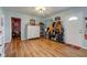 Open-concept living room with wood floors, ceiling light, a coat rack, and a view to the TV area at 115 N Spring St, Greenfield, IN 46140