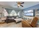 Bright living room with a leather couch, decorative shelving, large television, and a ceiling fan at 115 N Spring St, Greenfield, IN 46140