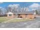 Brick home's backyard with a patio area and mature trees at 1313 Oakwood Trl, Indianapolis, IN 46260
