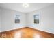 Bright bedroom featuring wood floors and two large windows at 1313 Oakwood Trl, Indianapolis, IN 46260