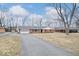 Charming brick ranch-style home with an attached garage and a long driveway at 1313 Oakwood Trl, Indianapolis, IN 46260