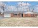 Charming brick ranch-style home with an attached garage and a well-maintained front yard at 1313 Oakwood Trl, Indianapolis, IN 46260