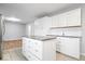 This bright kitchen features white cabinets, an island, and updated appliances at 1313 Oakwood Trl, Indianapolis, IN 46260
