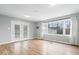Bright living room featuring hardwood floors and a window overlooking the backyard at 1313 Oakwood Trl, Indianapolis, IN 46260