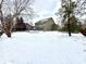 Backyard view of house with patio, retaining wall, and a large snow-covered area at 14596 Toponas Pl, Fishers, IN 46040