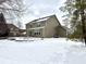 Backyard view of home with a raised stone patio and snow-covered yard at 14596 Toponas Pl, Fishers, IN 46040