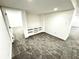 View of finished basement with built-in shelving, neutral carpet, and freshly painted white walls at 14596 Toponas Pl, Fishers, IN 46040