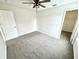 Bright bedroom featuring neutral walls, soft gray carpet, ceiling fan, and doorway to a walk-in closet at 14596 Toponas Pl, Fishers, IN 46040