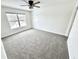 A cozy bedroom featuring neutral carpet, a ceiling fan, and a bright window at 14596 Toponas Pl, Fishers, IN 46040