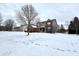 Side view of a brick home with a partially covered porch surrounded by a snow covered yard at 14596 Toponas Pl, Fishers, IN 46040