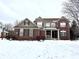 Attractive two-story brick home with a welcoming front porch and snow-covered yard at 14596 Toponas Pl, Fishers, IN 46040