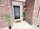 Cozy front porch featuring a black front door, brick accents, and decorative plants at 14596 Toponas Pl, Fishers, IN 46040