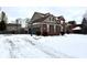 Two car garage and driveway covered with snow next to a two-story brick home at 14596 Toponas Pl, Fishers, IN 46040