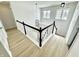 Bright hallway with wood floors and a modern black and white staircase and railing at 14596 Toponas Pl, Fishers, IN 46040