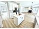 Open-concept kitchen with white cabinets, island, and stainless steel refrigerator leading to the living room at 14596 Toponas Pl, Fishers, IN 46040