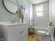 Bright bathroom featuring a modern vanity, decorative mirror, and a shower-over-tub setup with white marble-style tile surround at 17 Parkview Ave, Indianapolis, IN 46201