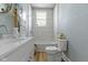 Bright bathroom featuring a modern vanity, decorative mirror, and a shower-over-tub setup with white marble-style tile surround at 17 Parkview Ave, Indianapolis, IN 46201