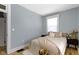 Cozy bedroom with natural light, neutral walls, wood-look flooring, and a comfortable bed with stylish throw pillows at 17 Parkview Ave, Indianapolis, IN 46201
