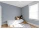 Bedroom with neutral walls, white trim, wood-look flooring, natural light, with rug and decorative items at 17 Parkview Ave, Indianapolis, IN 46201