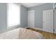 Bedroom with neutral walls, white trim, wood-look flooring, natural light, and updated baseboards at 17 Parkview Ave, Indianapolis, IN 46201