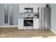 Updated kitchen features stainless steel appliances, white cabinetry and countertops and wood-look flooring at 17 Parkview Ave, Indianapolis, IN 46201