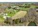 An aerial view shows a spacious lot featuring a cleared field, sparse trees, and a nearby pond at 1828 W 750 S, Trafalgar, IN 46181