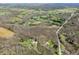 This aerial perspective captures the property's layout with a mix of wooded areas, homes, and a small pond at 1828 W 750 S, Trafalgar, IN 46181