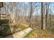 View of backyard featuring a small wooden deck, stone wall and a wooden walkway at 1828 W 750 S, Trafalgar, IN 46181