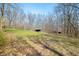 Scenic backyard features wooded area and storage sheds on a grassy hill, perfect for nature lovers at 1828 W 750 S, Trafalgar, IN 46181