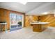 View of the finished basement, featuring a kitchenette, sliding glass door, and wood paneled walls at 1828 W 750 S, Trafalgar, IN 46181
