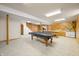 Finished basement with a pool table, staircase, wood paneling and an adjacent kitchenette at 1828 W 750 S, Trafalgar, IN 46181