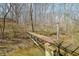 A small bridge spanning a stream, enveloped by lush foliage and trees in a wooded setting at 1828 W 750 S, Trafalgar, IN 46181