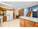 This kitchen features an island, stone countertops, wooden cabinets, and views to the stairs at 1828 W 750 S, Trafalgar, IN 46181
