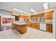 A traditional style kitchen features tile floors, wooden cabinets, and an island with granite countertops at 1828 W 750 S, Trafalgar, IN 46181
