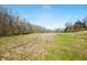 Open grass land with a small furrowed section and bordered by trees under a clear sky provides an idyllic pastoral scene at 1828 W 750 S, Trafalgar, IN 46181