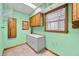 A laundry room features a white cabinet, tile floors, and green walls at 1828 W 750 S, Trafalgar, IN 46181