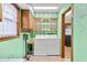A laundry room features a washer and dryer, tile floors, and green walls at 1828 W 750 S, Trafalgar, IN 46181