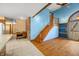 Bright living room featuring hardwood floors, exposed brick, a staircase, and natural light at 1828 W 750 S, Trafalgar, IN 46181
