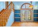 Living Room with hardwood floors, staircase, blue accent wall and light from glass doors at 1828 W 750 S, Trafalgar, IN 46181