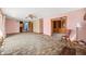 Spacious living room featuring pink walls, vintage carpet, with a brick fireplace, and a view to the backyard at 1828 W 750 S, Trafalgar, IN 46181