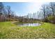 A serene pond reflects a clear sky, surrounded by trees, showcasing the natural beauty of the land and the spring season at 1828 W 750 S, Trafalgar, IN 46181