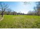 Expansive yard with green grass and scattered trees under a clear sky, offering serene outdoor space at 1828 W 750 S, Trafalgar, IN 46181